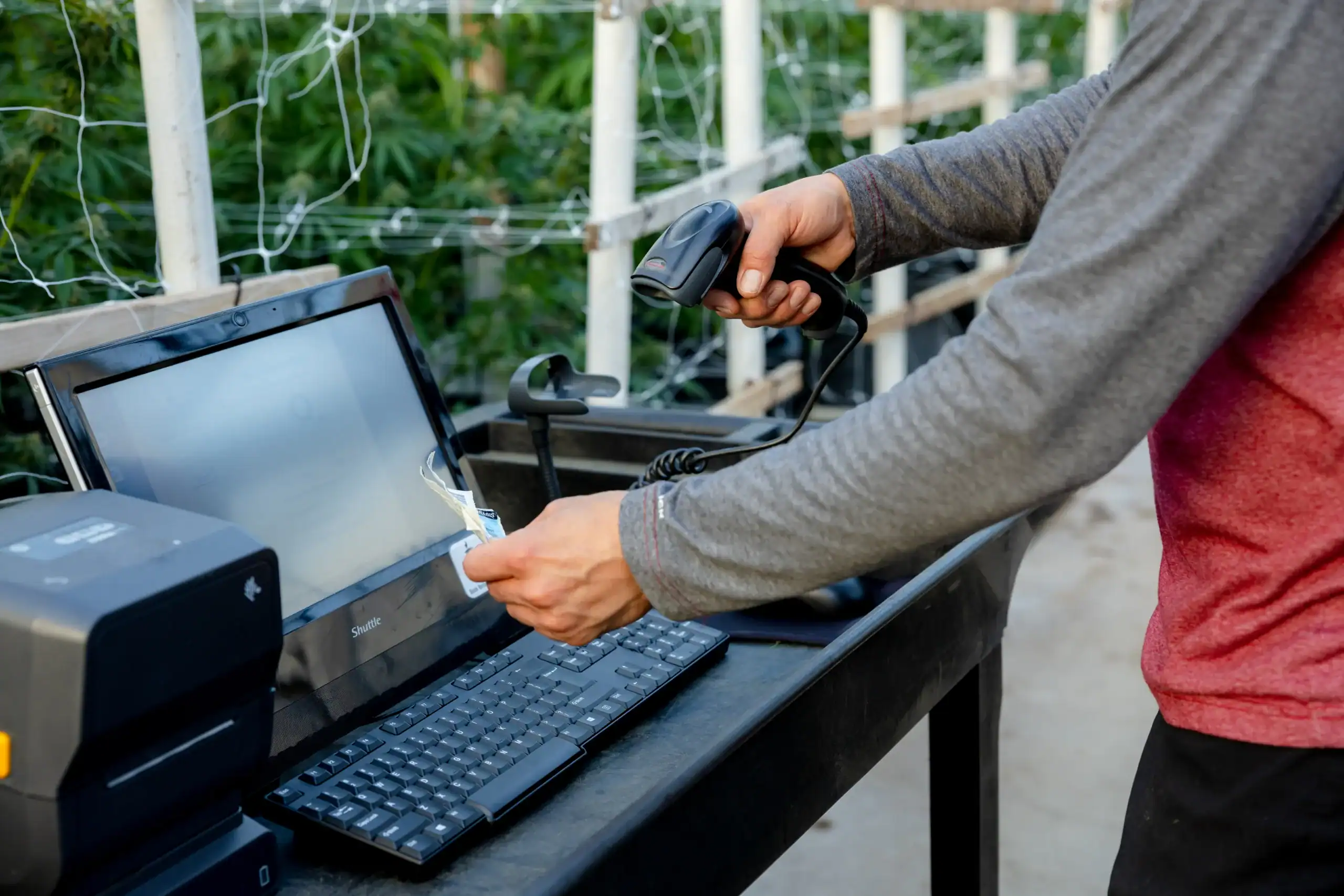 Operator scanning a plant tag at a weigh station with a label printer and terminal